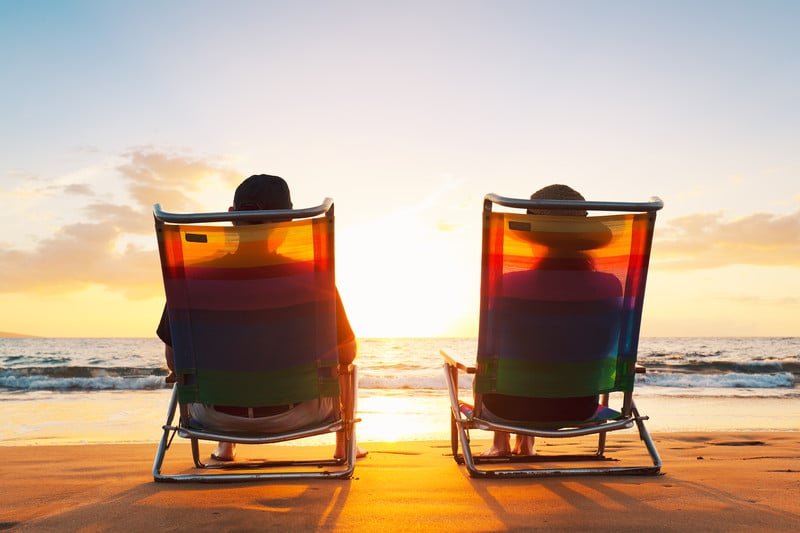 Happy Retired Couple Enjoying Beautiful Sunset At The Beach